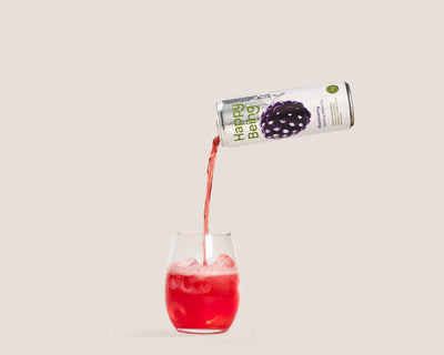 Happy Being Blackberry Sparkling White Tea poured over ice into a refreshing glass.