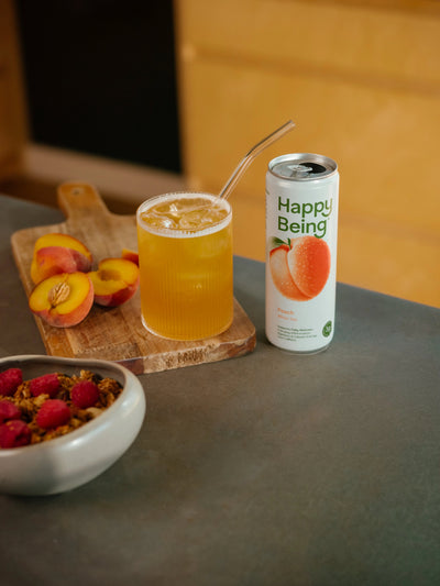 Happy Being Peach White Tea served iced with fresh peach slices.