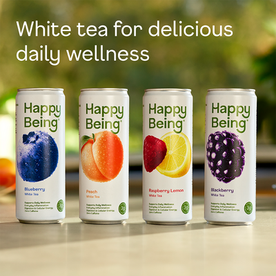 Four cans of 'Happy Being' white tea with fruit illustrations on a blurred natural background