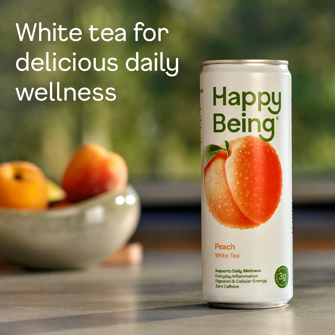 Can of Happy Being Peach White Tea with fresh peach imagery, highlighting a light, refreshing, low-sugar wellness drink.