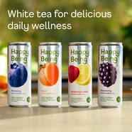 Four cans of 'Happy Being' white tea with fruit illustrations on a blurred natural background