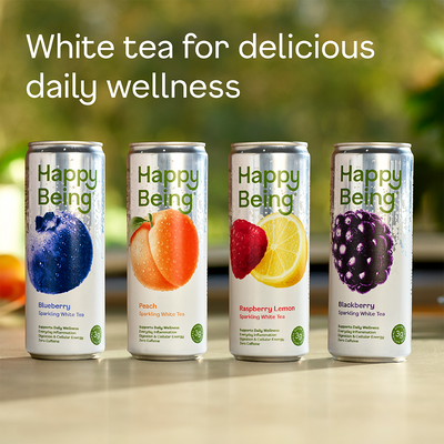 Four cans of 'Happy Being' white tea with fruit illustrations on a blurred natural background