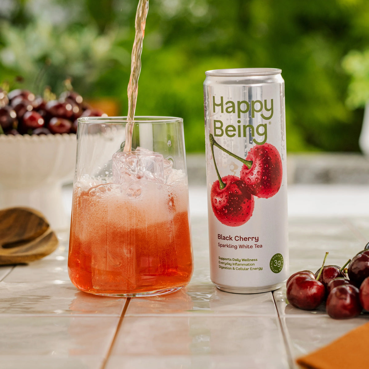 Can of Happy Being Black Cherry Sparkling White Tea with black cherry imagery, featuring a refreshing lightly sparkling white tea.