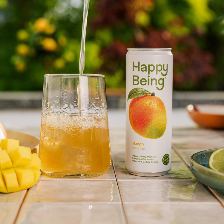 Happy Being mango drink poured into a glass.