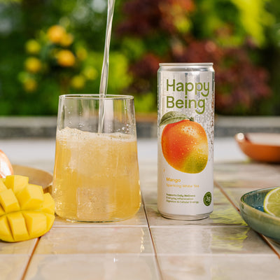 Happy Being sparkling mango drink poured into a glass.