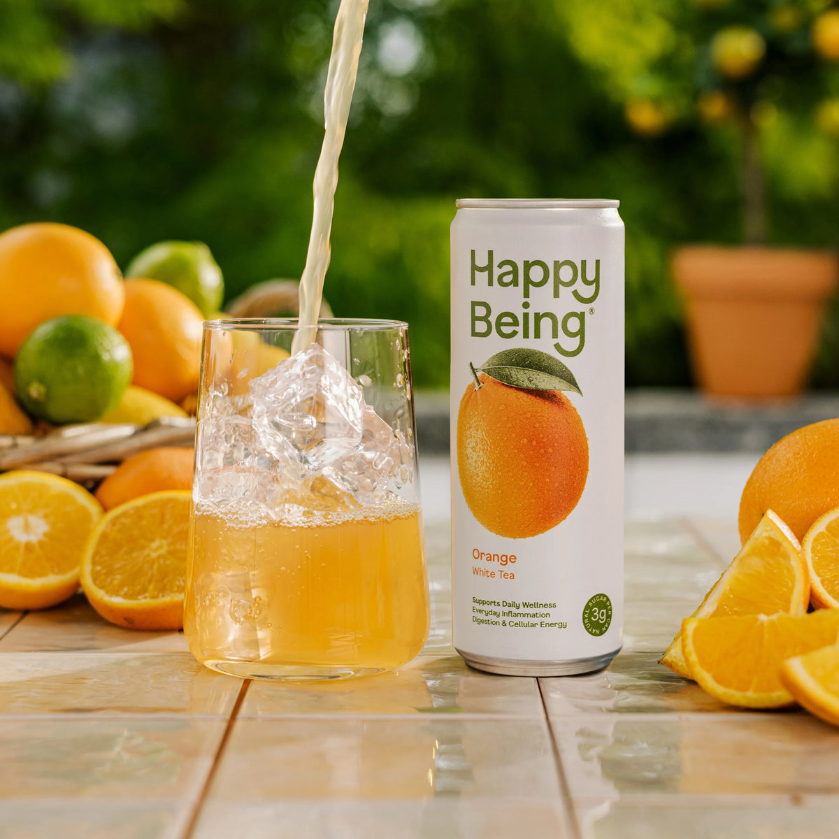 Can of Happy Being Orange White Tea with fresh orange imagery, featuring a bright and refreshing still white tea.