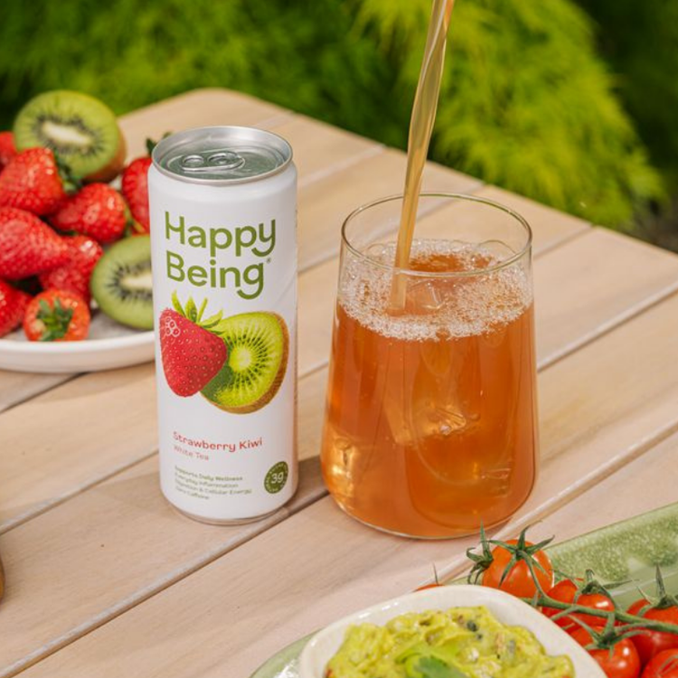 Happy Being Strawberry Kiwi poured over ice beside fresh fruit