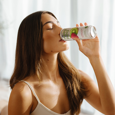 Woman drinking Happy Being strawberry kiwi white tea.