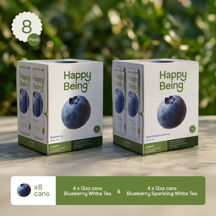 Two boxes of Happy Being Blueberry White Tea on a wooden surface with a blurred green background.